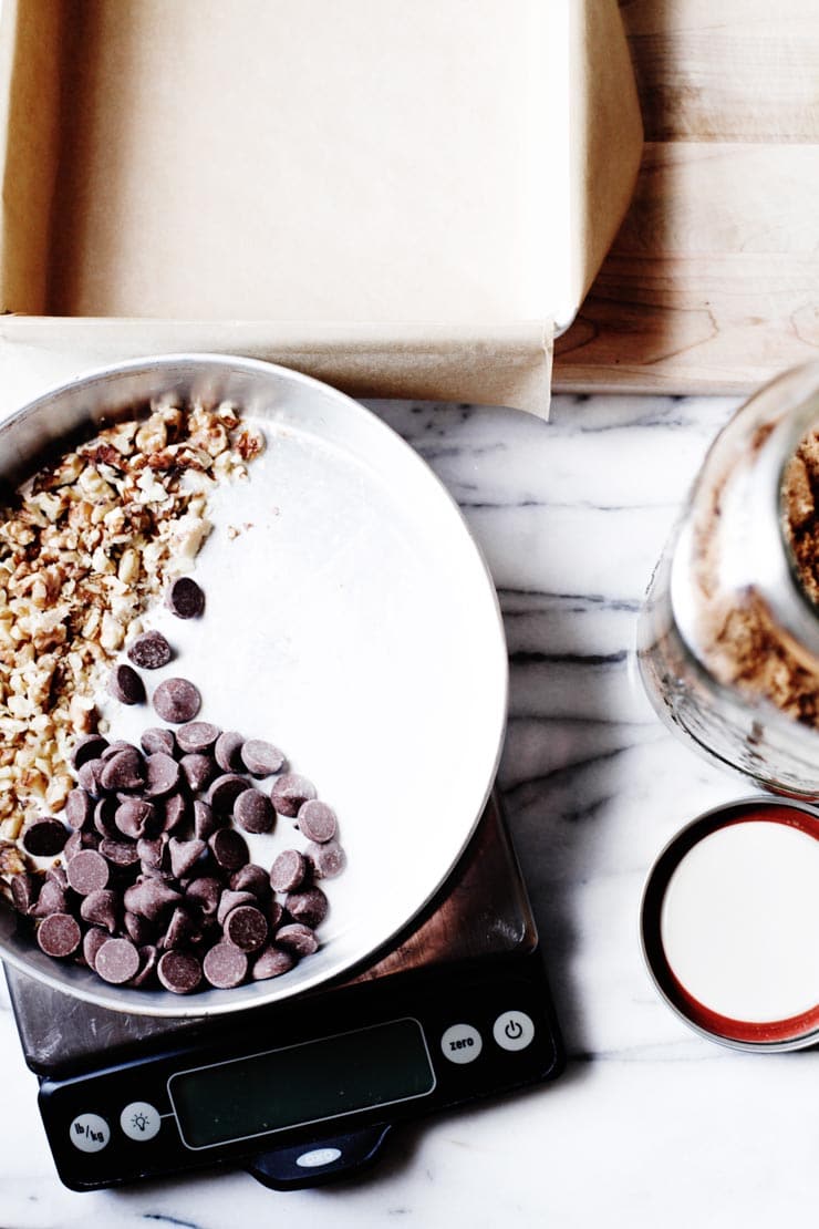 Brown sugar in jar, chocolate and walnuts in pan on scale