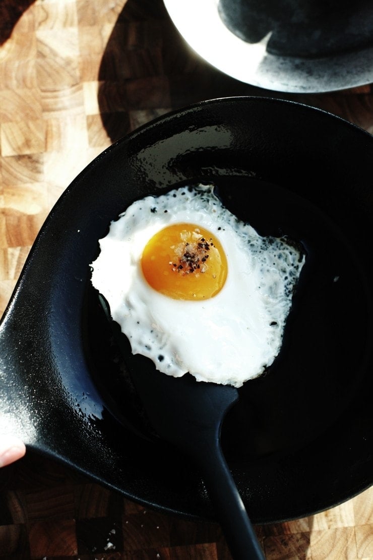 Flip fried egg in cast-iron skillet to have an egg over easy